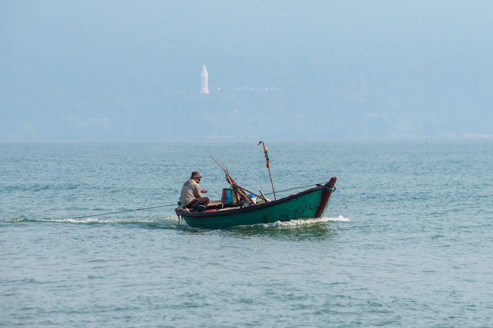 a man in a green boat on the water