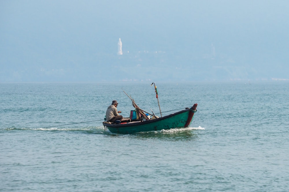 Ein Mann in einem grünen Boot auf dem Wasser