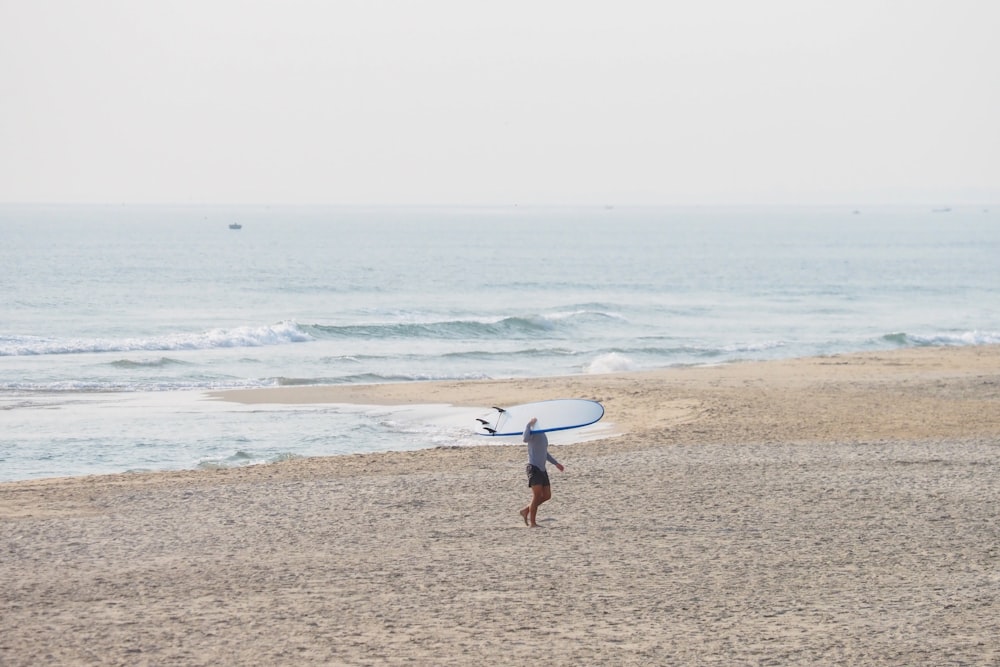 a person on a beach with a surfboard