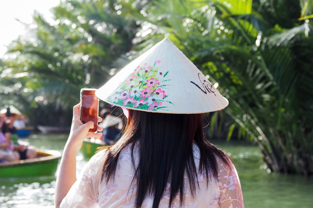 a woman with a hat on her head taking a picture