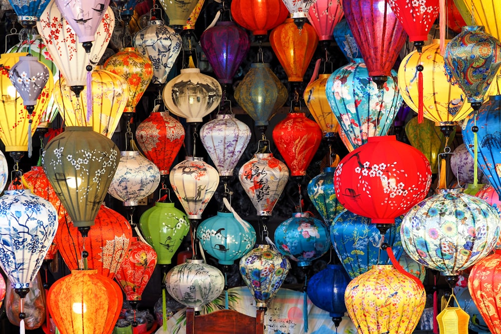 a bunch of colorful lanterns hanging from a ceiling