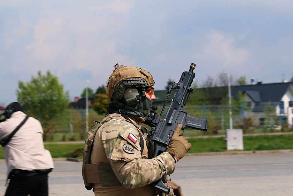 a man in camouflage holding a machine gun