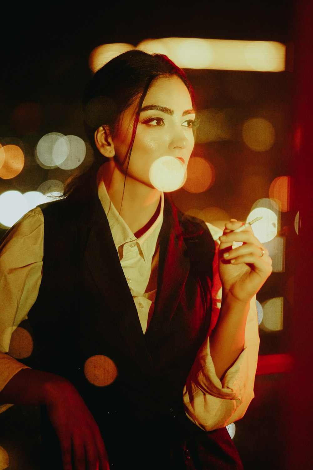 a woman smoking a cigarette in a dark room