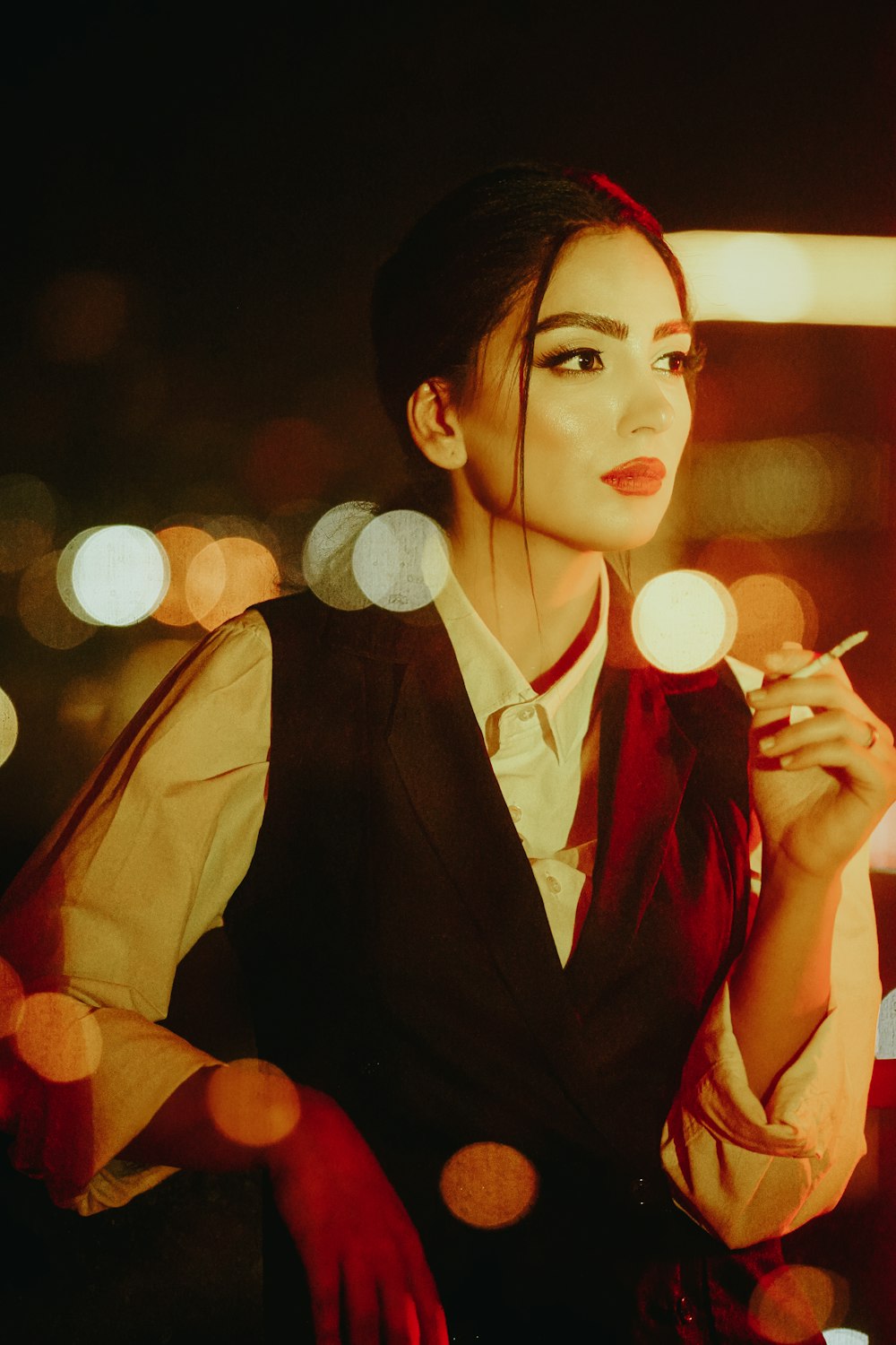 a woman smoking a cigarette in a dark room