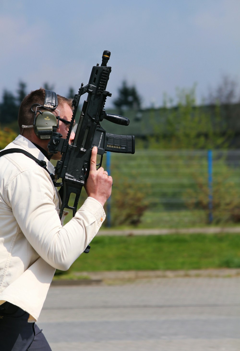 a man in a white suit holding a rifle