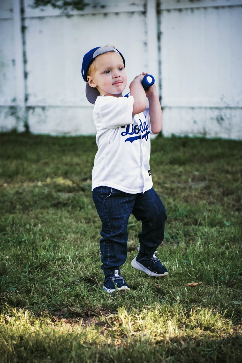 a young boy holding a baseball bat on top of a field