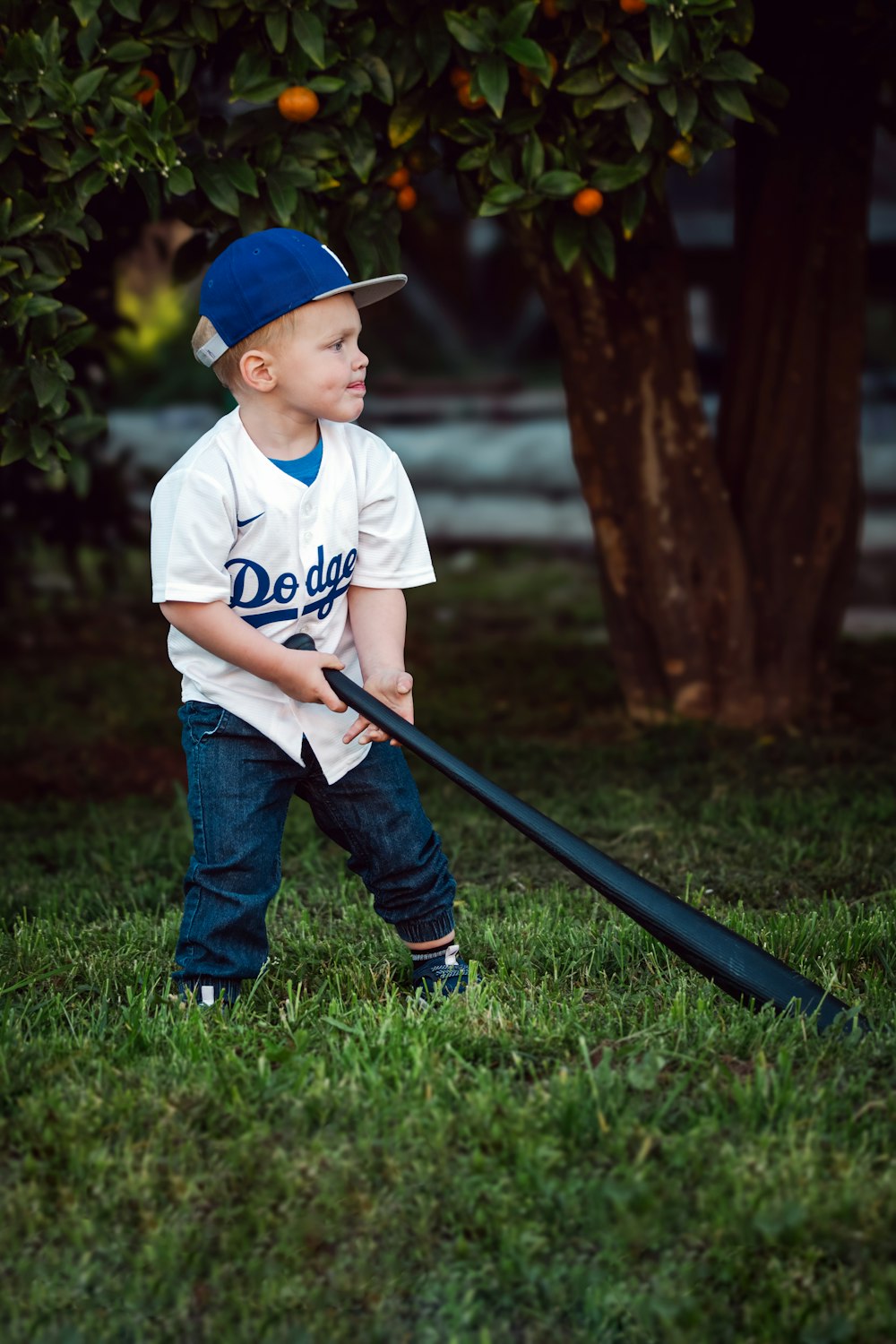 Ein kleiner Junge hält einen Baseballschläger auf einem Feld