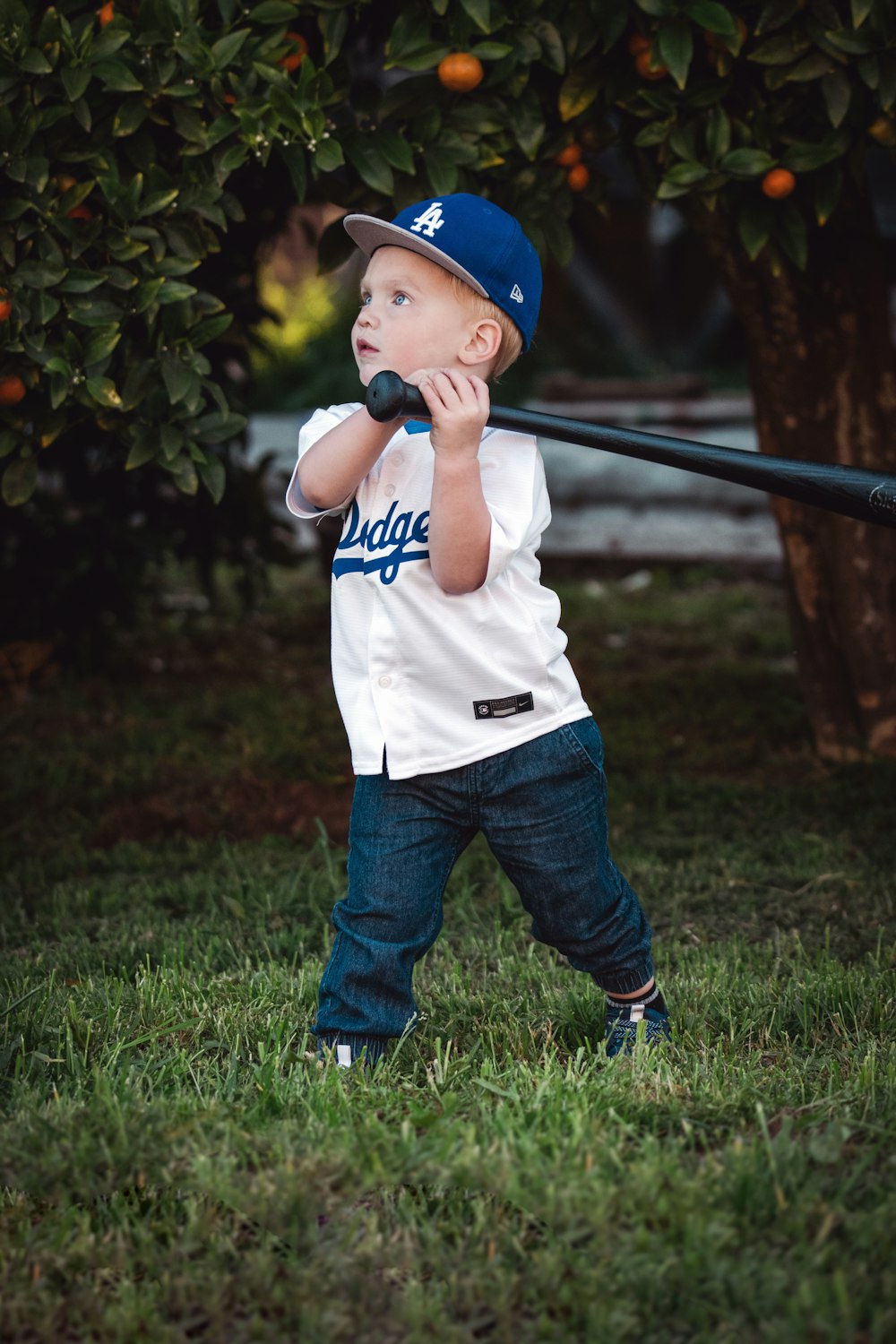 a young boy holding a baseball bat on top of a field