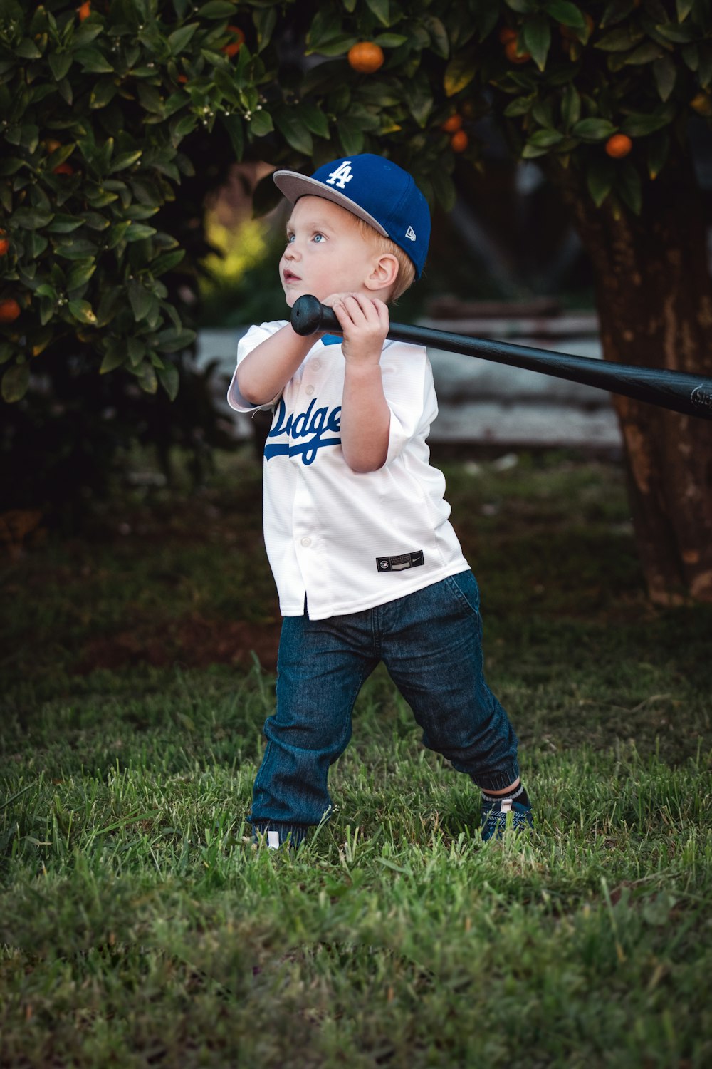 Un niño sosteniendo un bate de béisbol en la parte superior de un campo