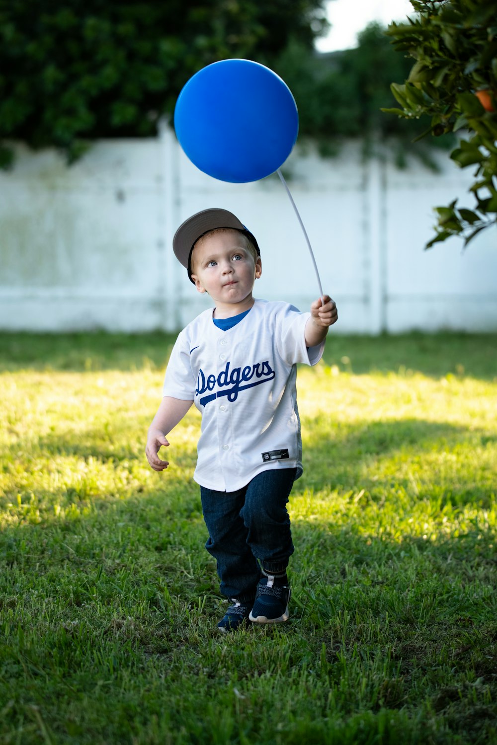 Ein kleiner Junge hält sich an einem blauen Luftballon fest