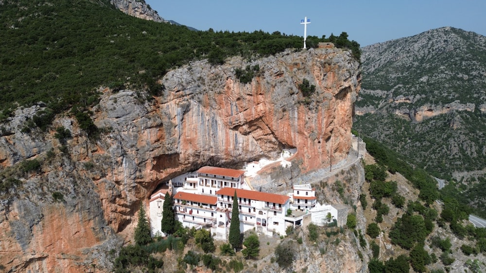 um edifício branco em um penhasco com uma cruz em cima dele