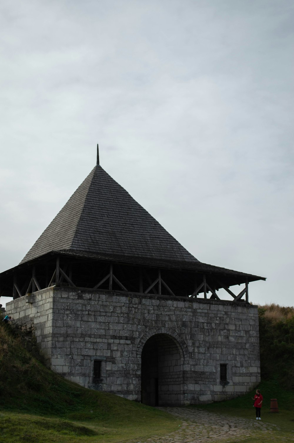 a stone structure with a roof on top of a hill