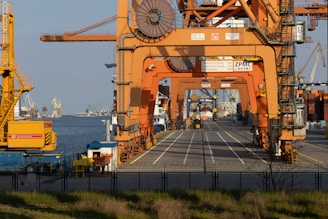 a large orange crane sitting on the side of a road