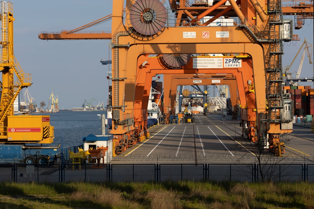 a large orange crane sitting on the side of a road