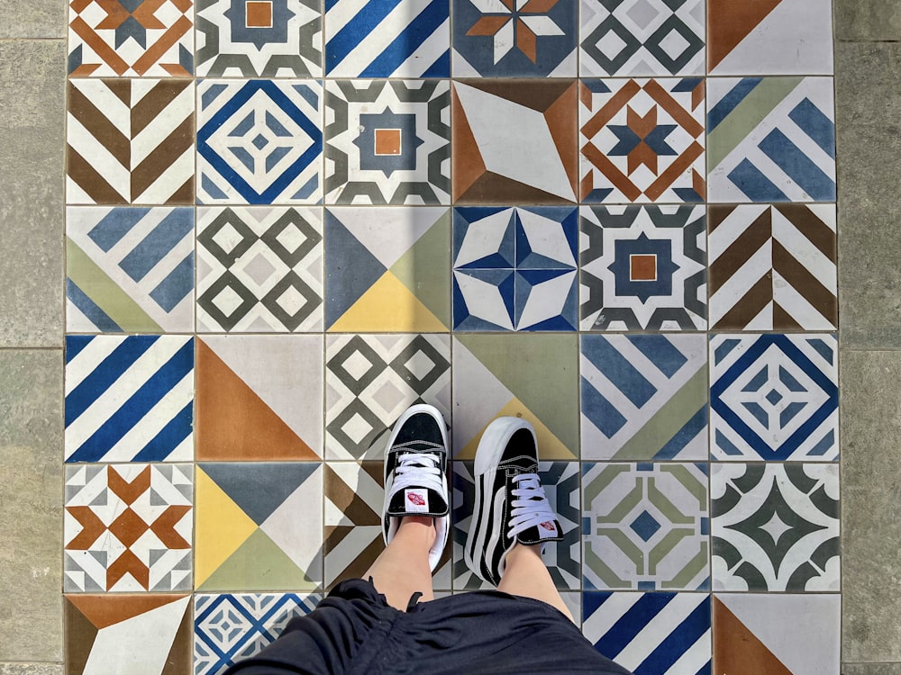 a person's feet resting on a tiled floor