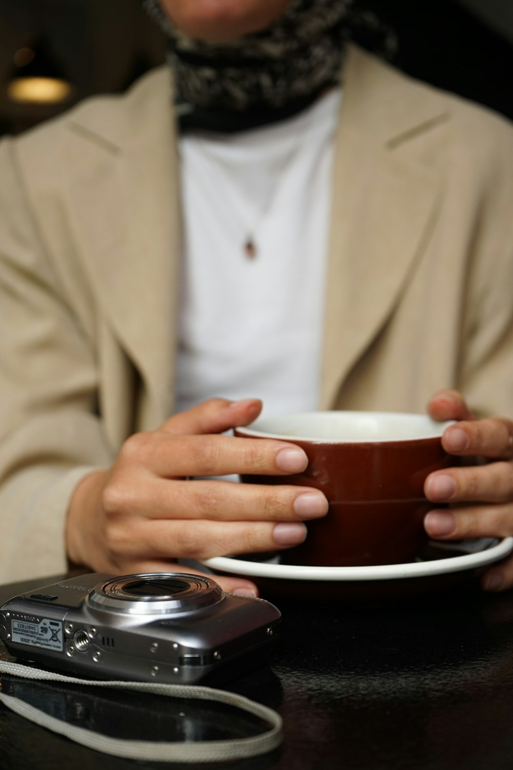 a person holding a coffee cup and a cell phone