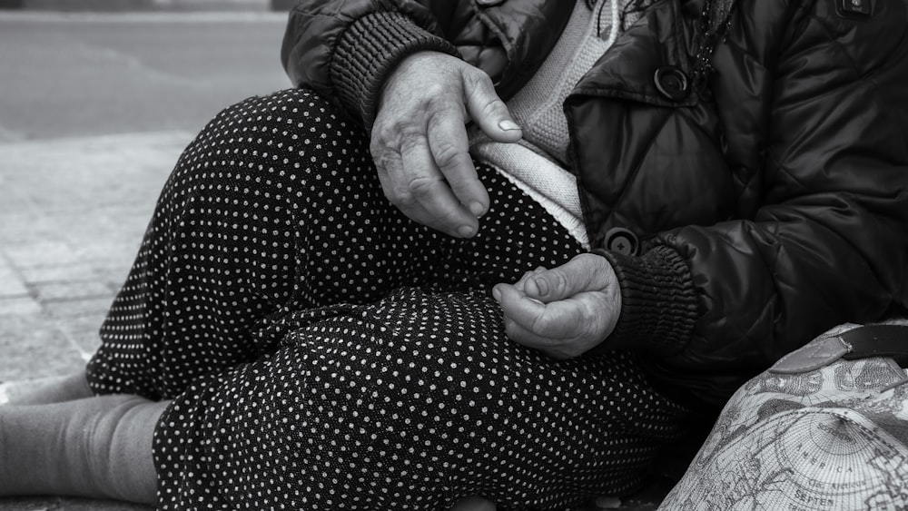 a woman sitting on the ground holding a cell phone