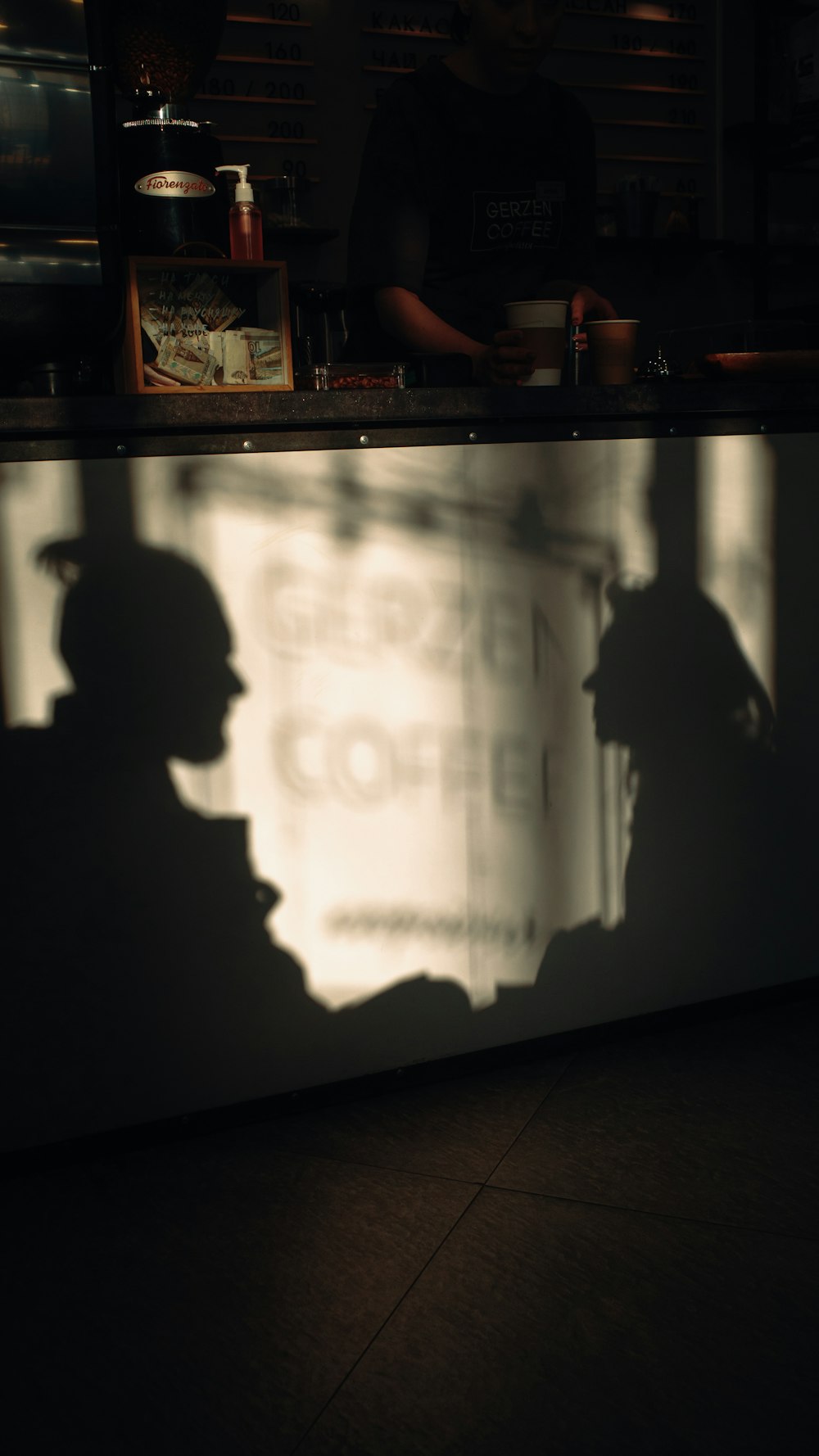 a shadow of a man standing in front of a counter