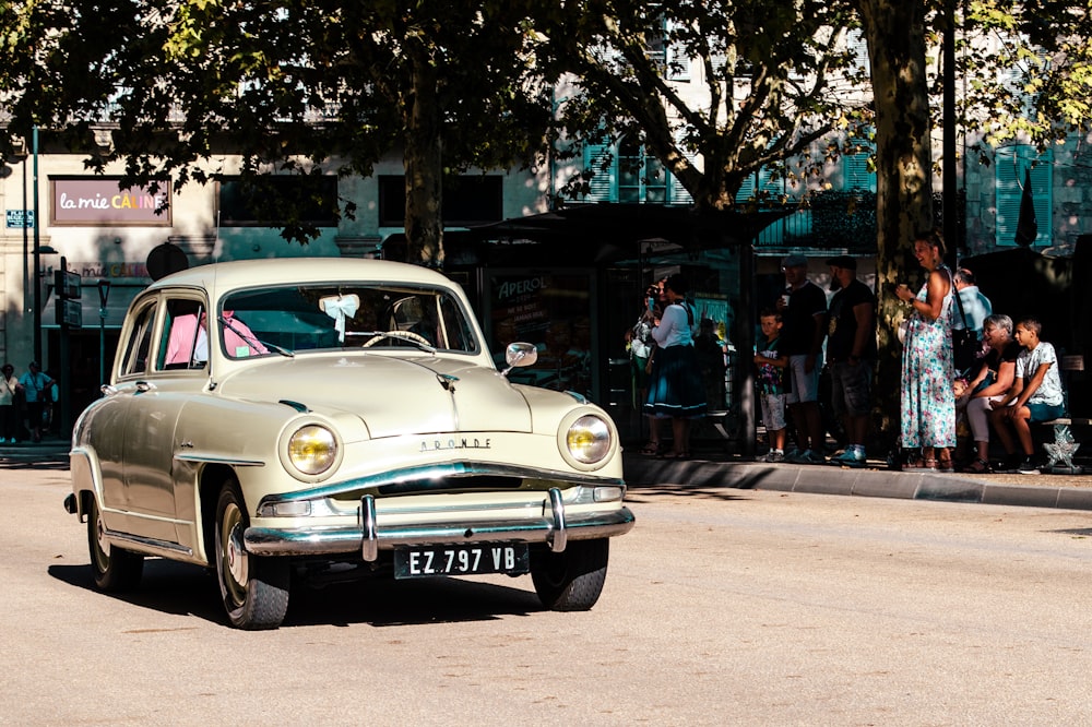 an old car is parked on the side of the road