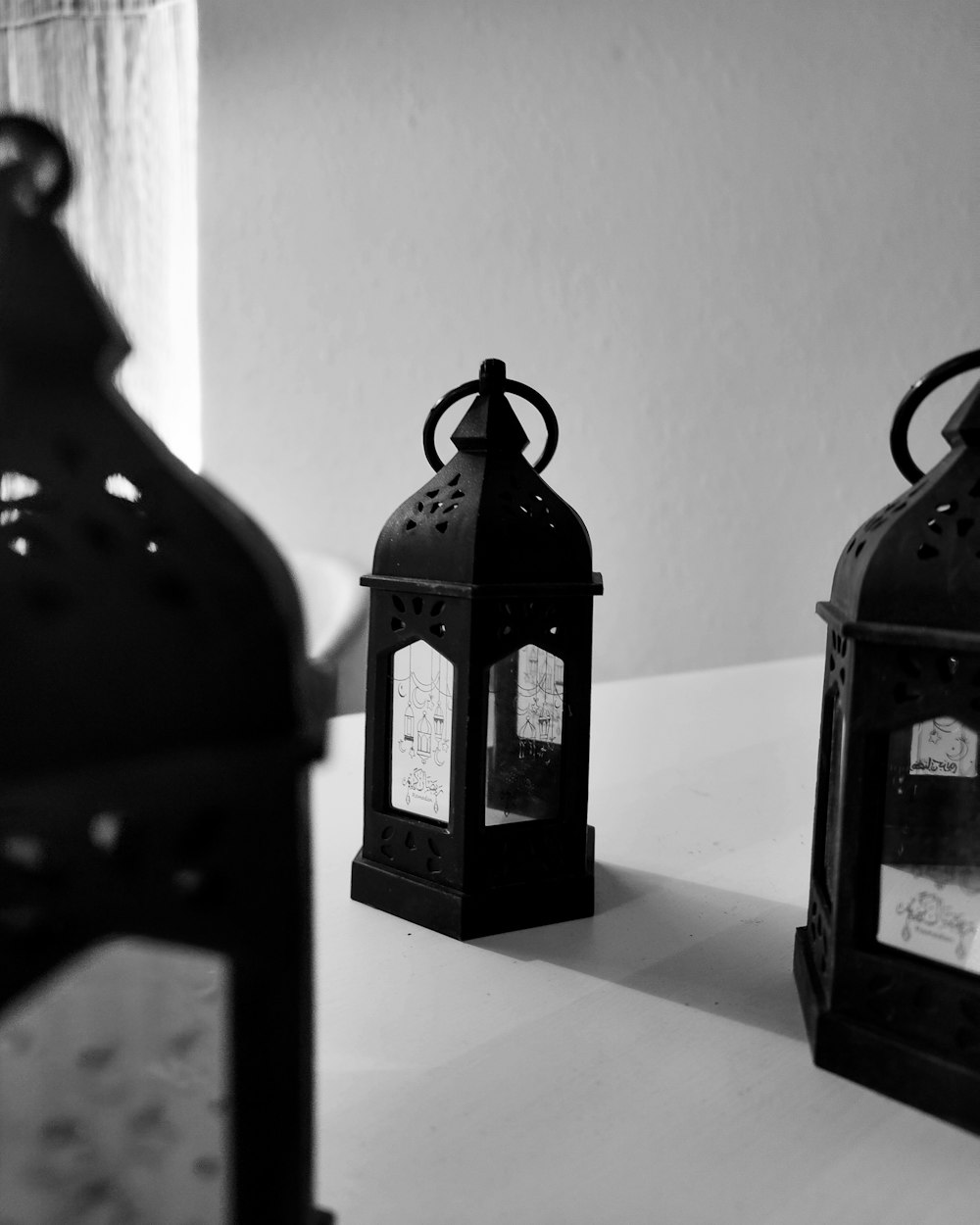 a couple of black lanterns sitting on top of a table