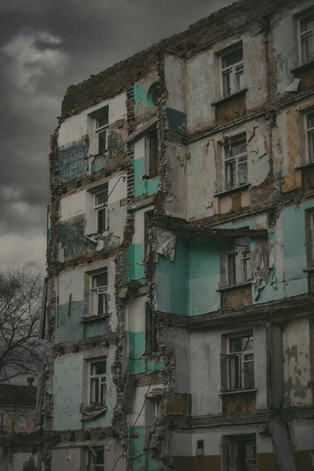 Un edificio muy antiguo con ventanas rotas y un reloj a un lado