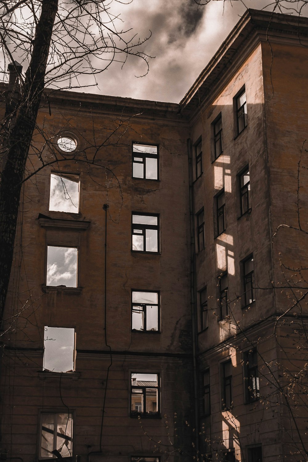 a tall building with lots of windows next to a tree