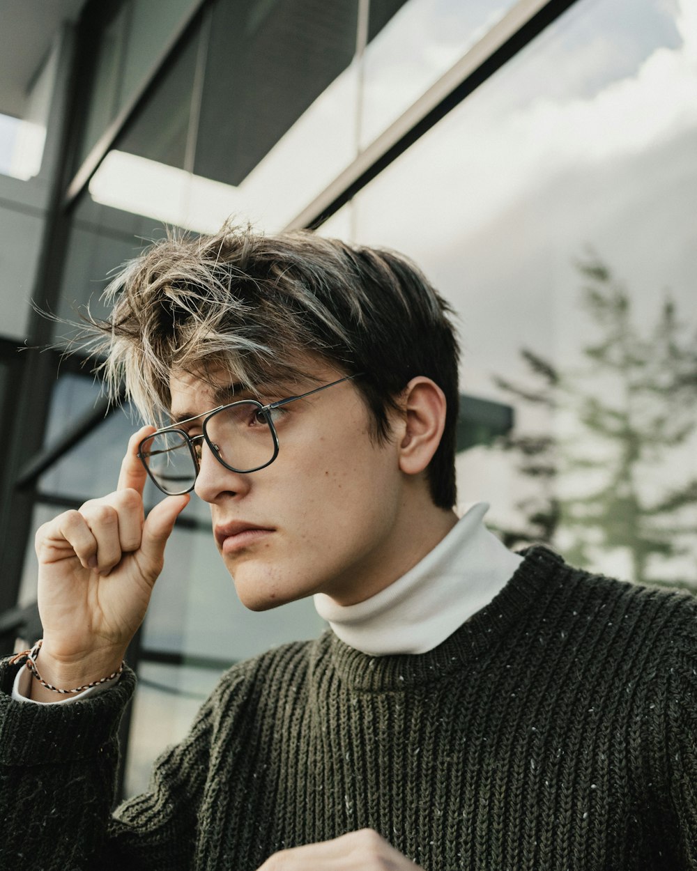 a man wearing glasses and a turtle neck sweater
