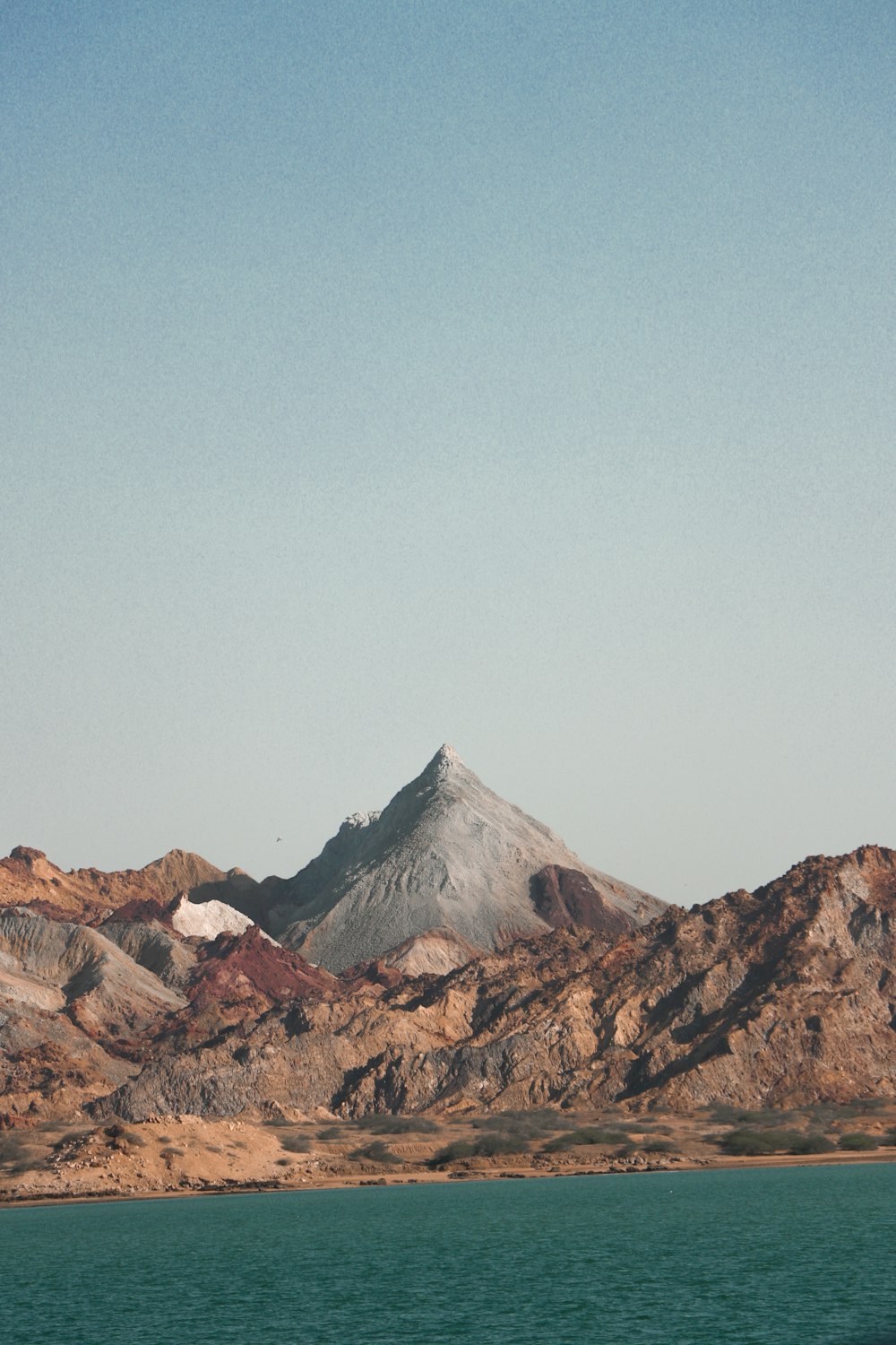 a large body of water with a mountain in the background