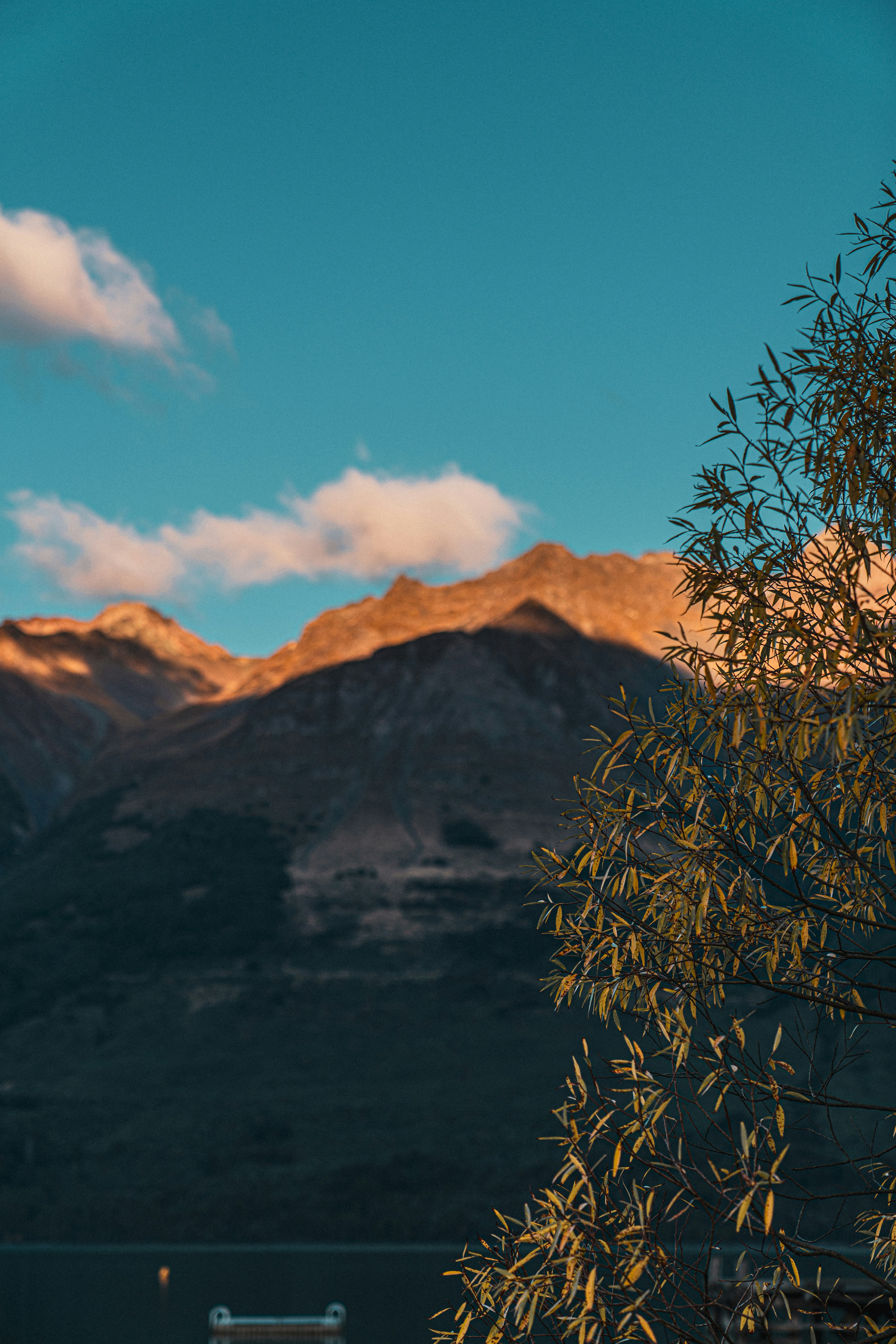 a view of a mountain range with a bench in the foreground