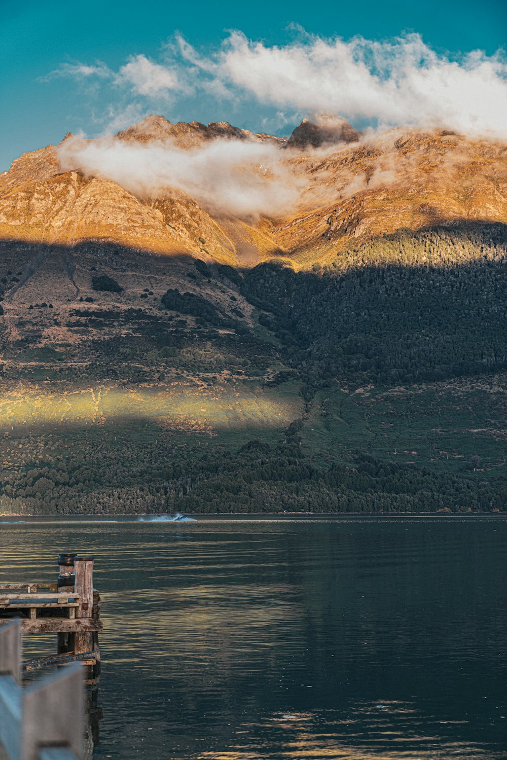 a lake with mountains in the background and a dock in the foreground