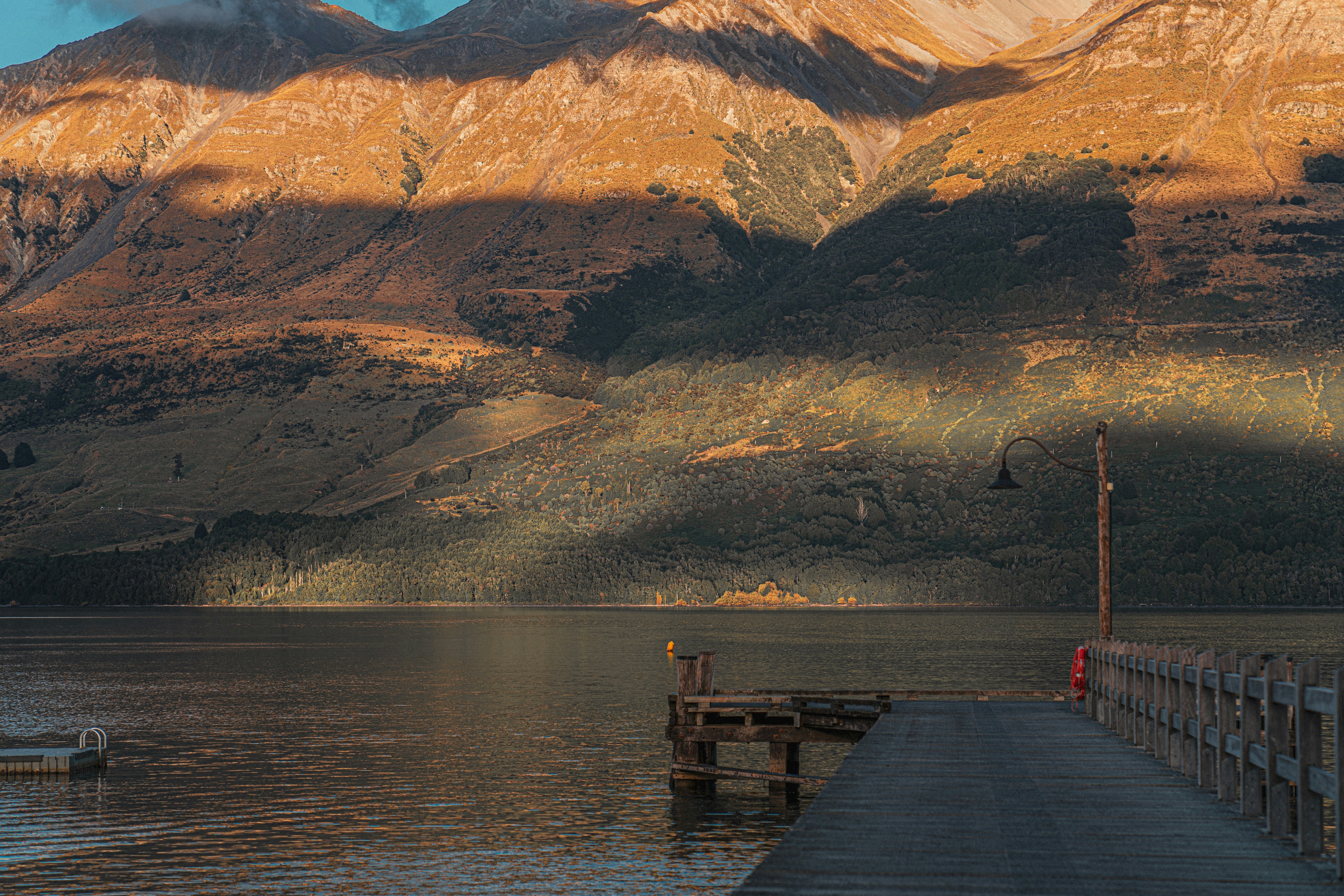 a pier on a lake with mountains in the background
