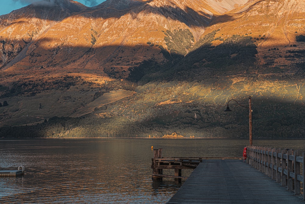 a pier on a lake with mountains in the background