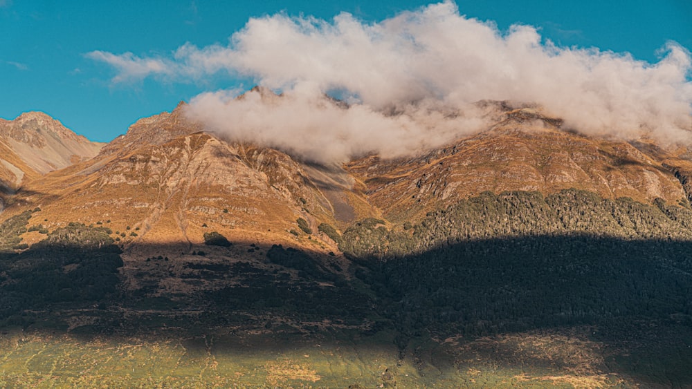 a mountain range with a few clouds in the sky