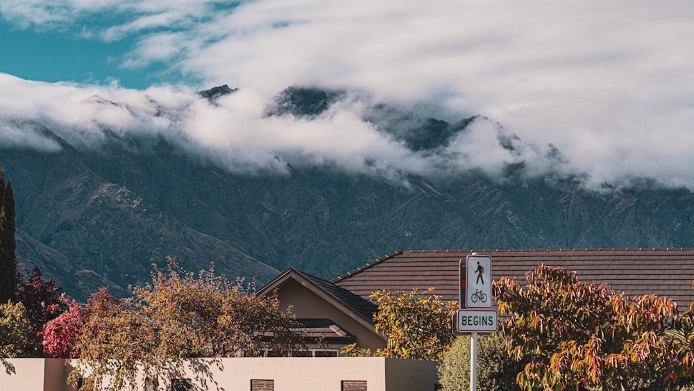 a street sign in front of a building with a mountain in the background