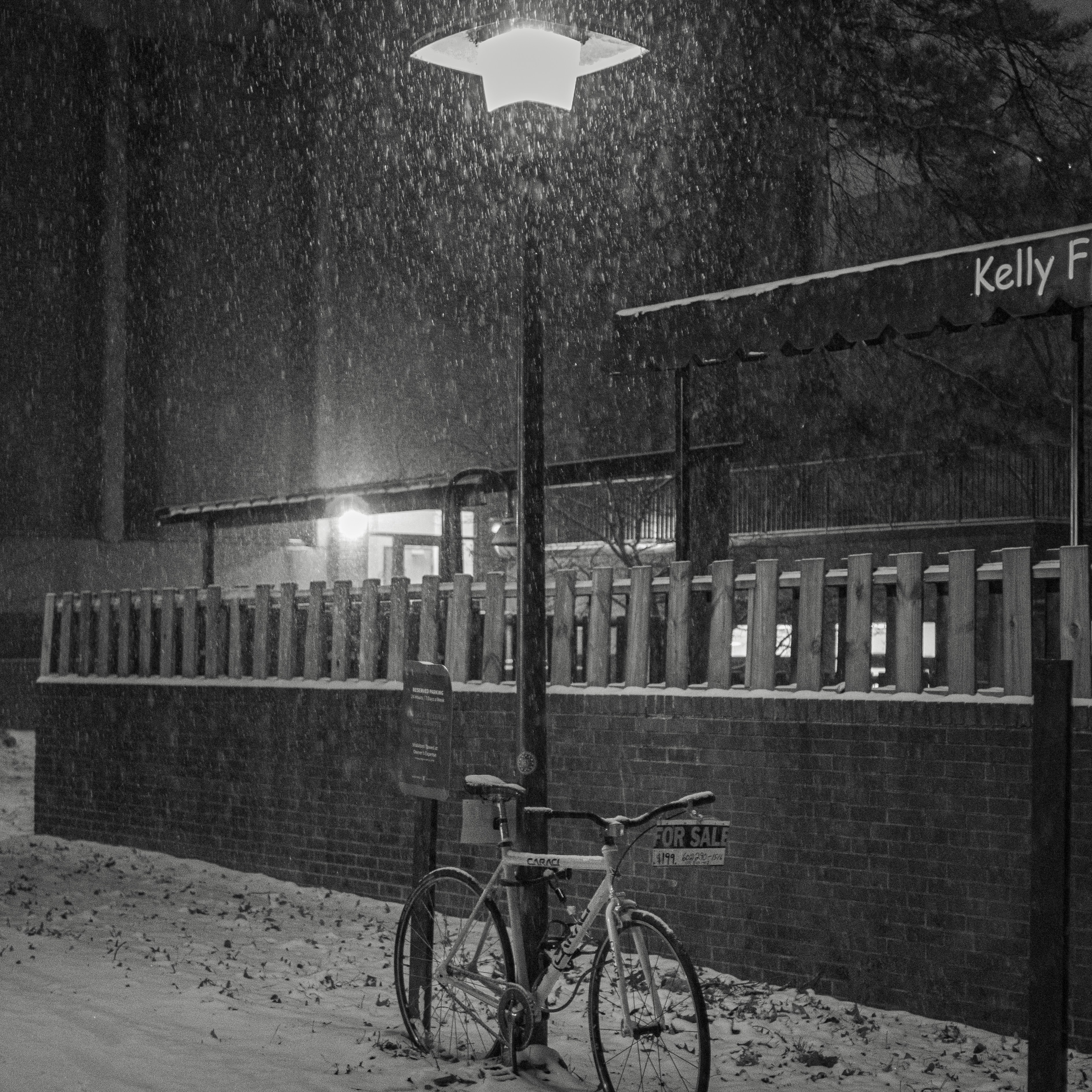 a bike parked next to a parking meter under a street light