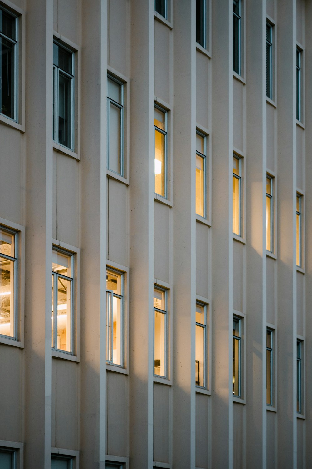 a tall building with lots of windows lit up at night