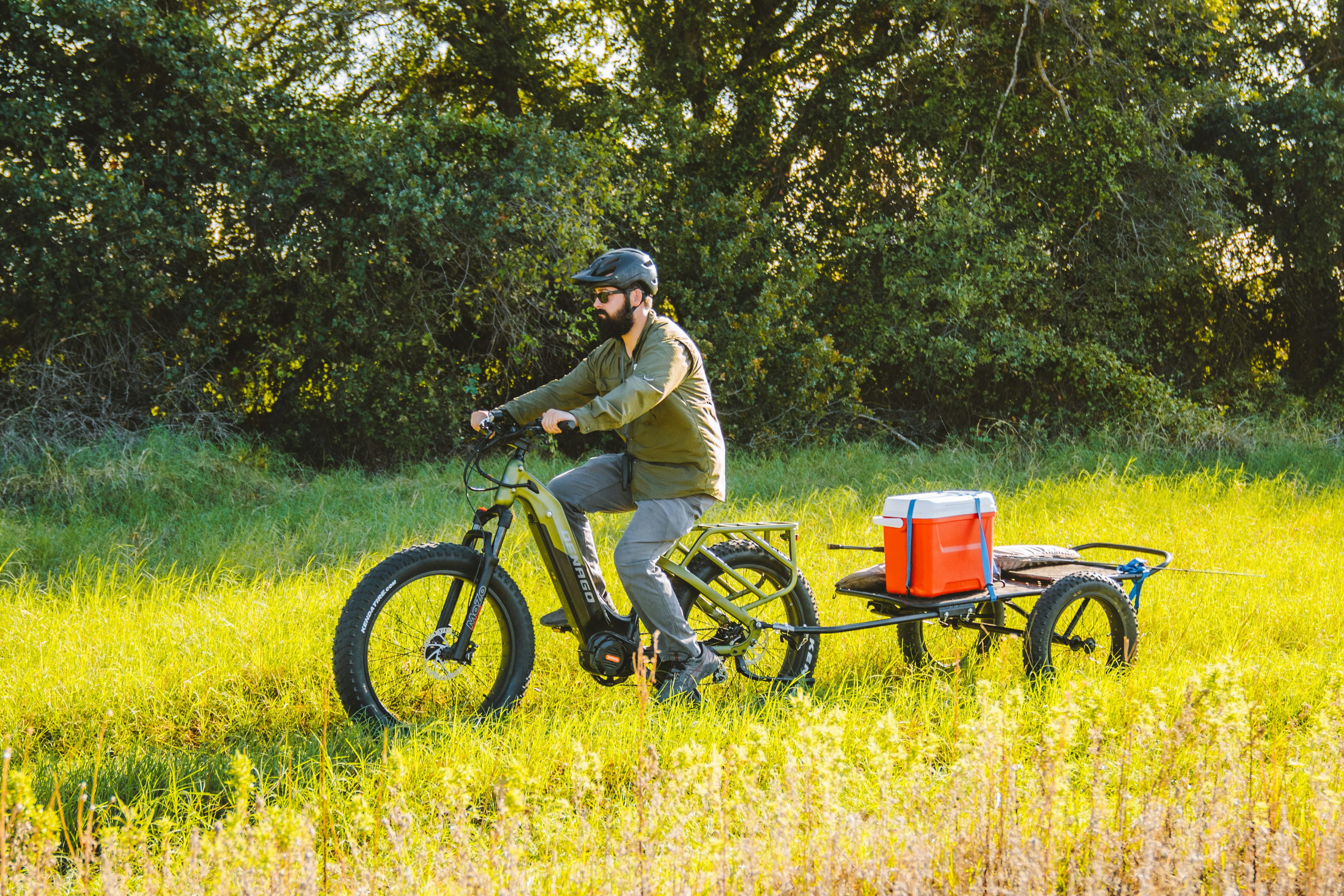 a man riding a bike with a trailer attached to it