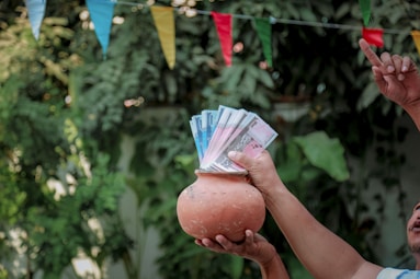 a man holding a pot with money in it