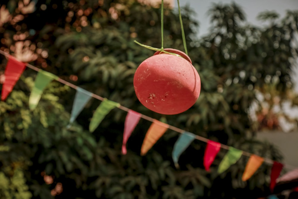 a red object hanging from a line of colorful flags