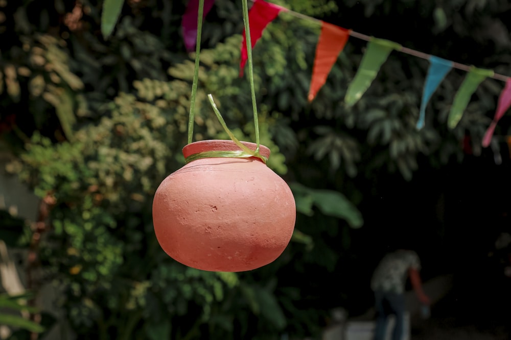 a pink pot hanging from a line of flags