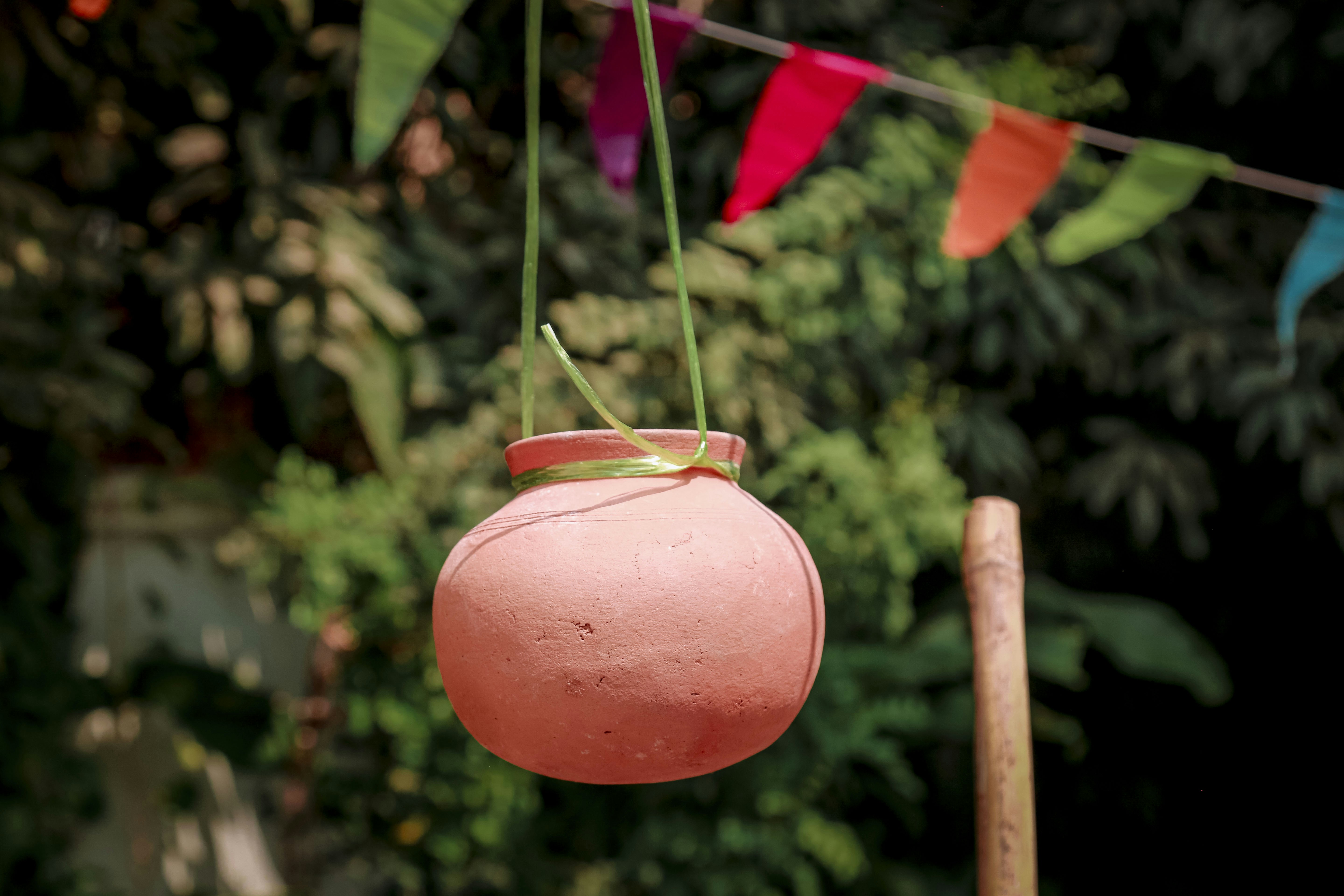 a pink pot hanging from a line of clothes