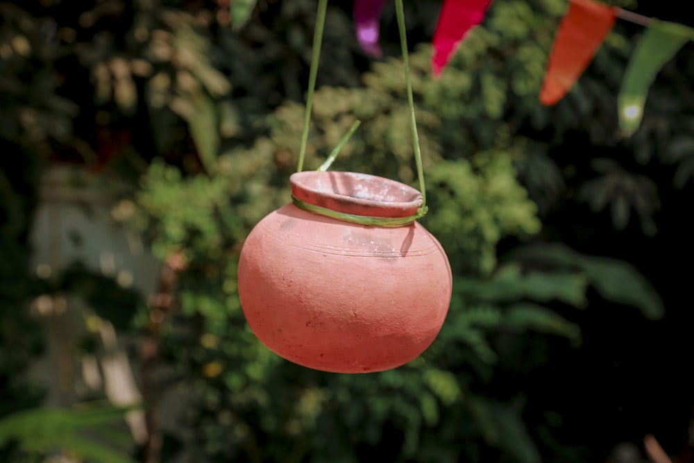 a pink pot hanging from a line of colorful flags