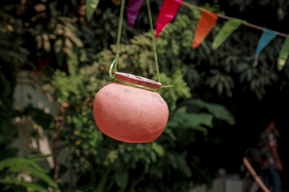 a pink pot hanging from a line of colorful flags