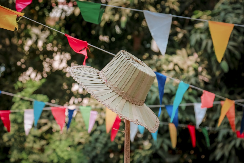 a white hat is on a stick in front of some flags