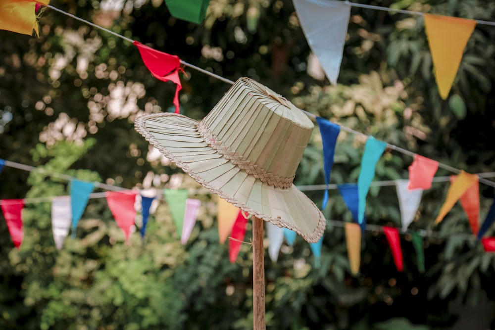 a straw hat on a stick in front of flags