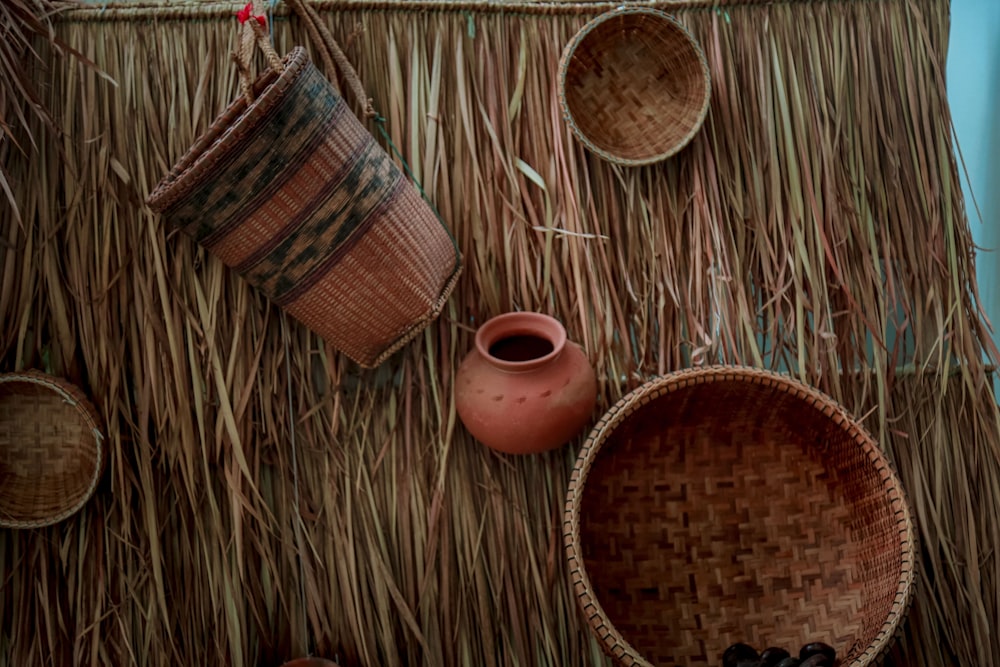 a straw hut with baskets and bowls on it