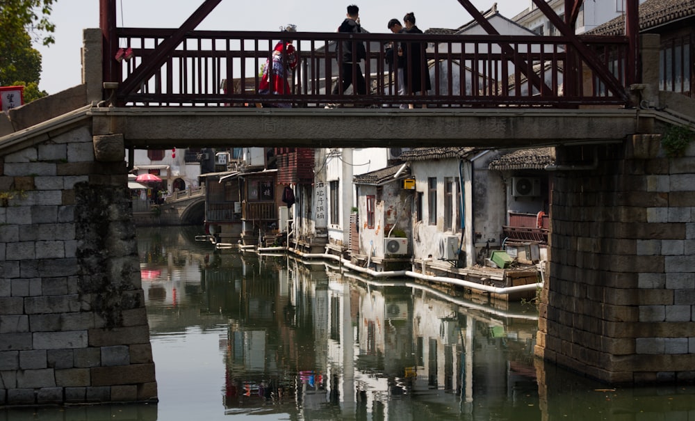 a group of people walking across a bridge over a river