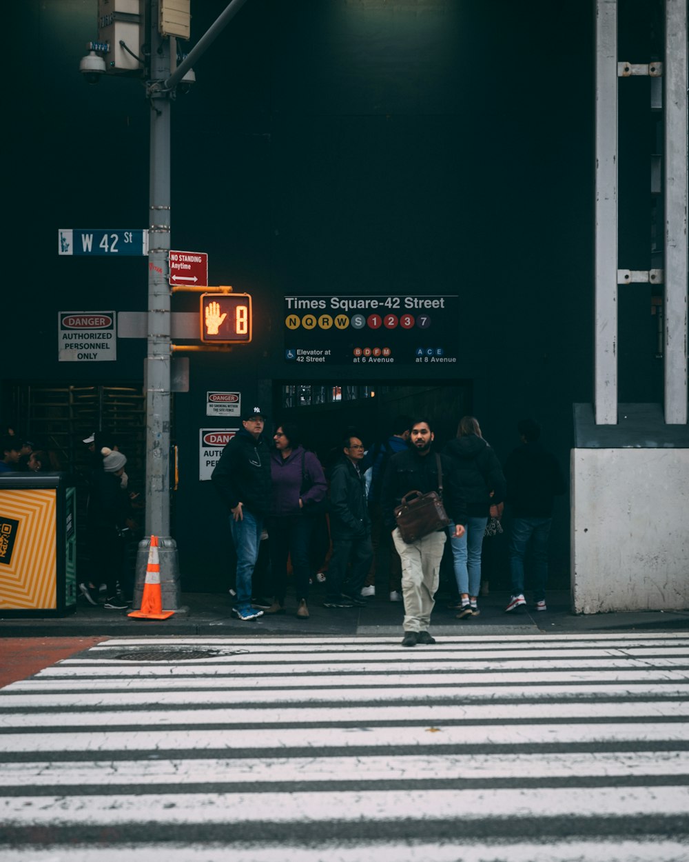 a group of people waiting at a cross walk