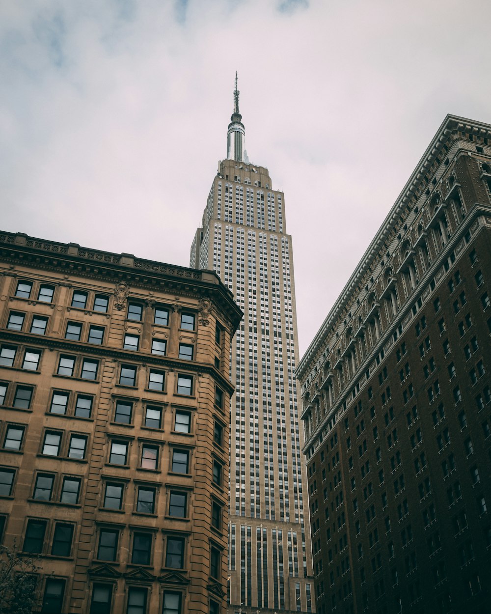 Un edificio alto que se eleva sobre una ciudad junto a otros edificios