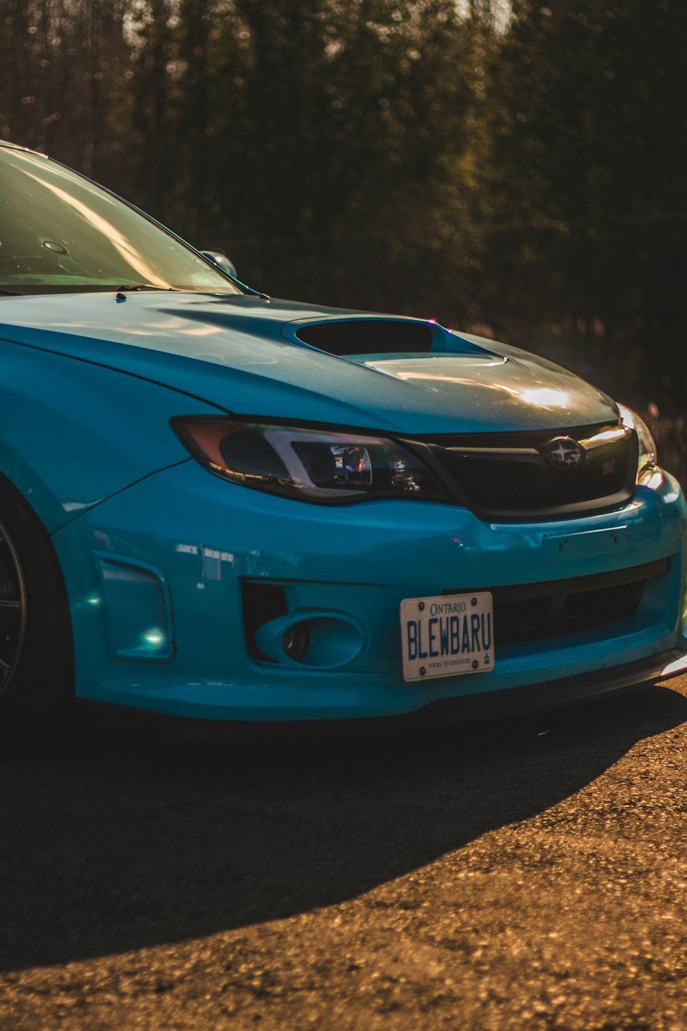 a blue subarunt is parked in a parking lot